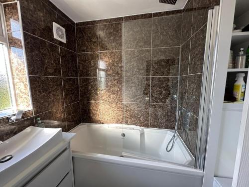 un baño con bañera y lavabo en Hare&Deer Home Stay, en Hither Green