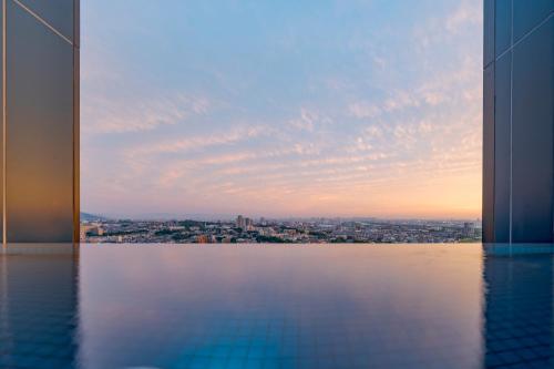 a view of a city from a pool in a building at Candeo Hotels Osaka Hirakata in Hirakata
