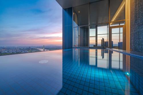 a swimming pool in a building with a view at Candeo Hotels Osaka Hirakata in Hirakata