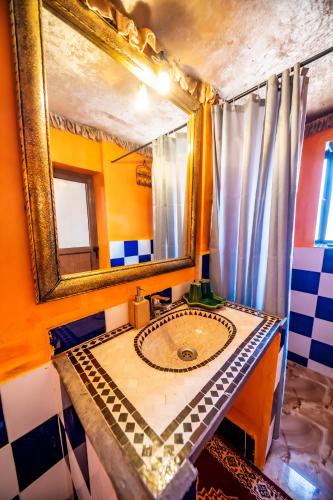 a bathroom with a sink and a mirror at Aladdin Desert Camp - Mhamid Erg Chigaga Escape in El Gouera