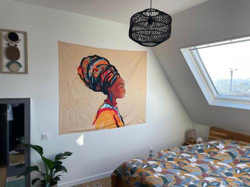 a painting of a woman on a wall next to a bed at Saint Malo Agréable maison familiale in Saint Malo