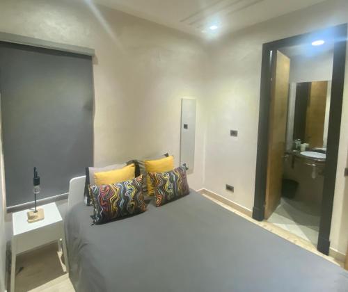 een slaapkamer met een bed met kussens en een wastafel bij Superbe appartement très bien situé in Casablanca