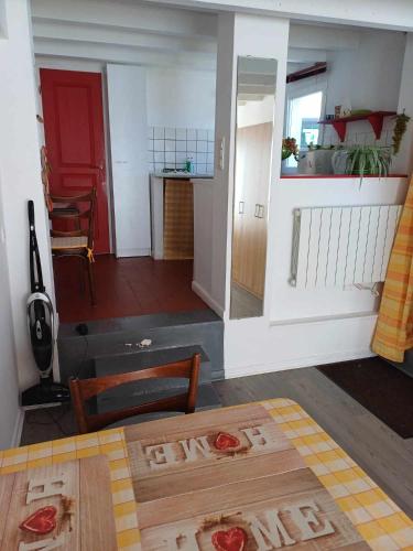 - un salon avec une table et une porte rouge dans l'établissement Studio meublé, à Antigny-la-Ville
