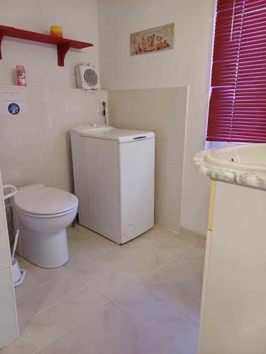 une salle de bain blanche avec des toilettes et un lavabo dans l'établissement Studio meublé, à Antigny-la-Ville