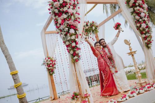 a bride and groom on a swing with flowers at Backwater Ripples Kumarakom in Kumarakom