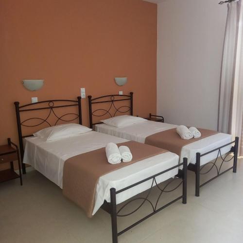 zwei Betten in einem Zimmer mit weißen Handtüchern in der Unterkunft Manolis Studios in Kefalos