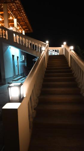 a staircase leading up to a building at night at Damodar River Retreat, Uluberia in Uluberiya