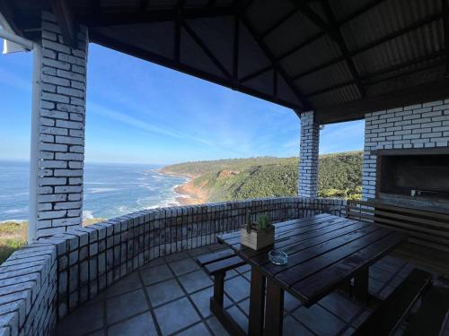 a balcony with a table and a view of the ocean at Blue Whale Resort in George