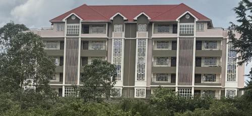a large apartment building with a red roof at Luxurious 2 bedroom penthouse-Fully Furnished at 360 Luxury in Kitale