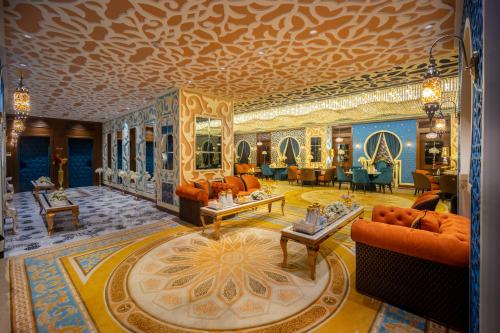 a living room with orange furniture and a gold ceiling at Donatello Jeddah Hotel in Jeddah