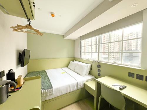 Mały pokój z łóżkiem i biurkiem w obiekcie Urbanwood Hung Hom w Hongkongu