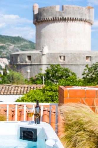 a table with two glasses of wine and a castle at Apartments Regjo in Dubrovnik