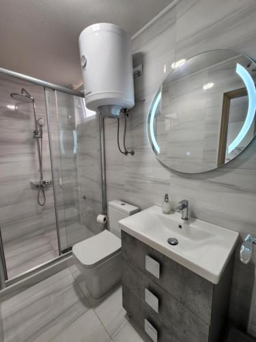 een badkamer met een toilet, een wastafel en een spiegel bij Melograno in Tivat