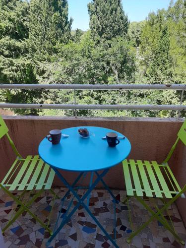 une table bleue et deux chaises sur un balcon dans l'établissement La Ciotat - T2 à 150m des plages avec parking privée, à La Ciotat