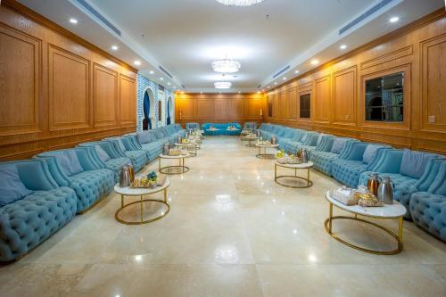 a large room with blue couches and tables at Donatello Jeddah Hotel in Jeddah