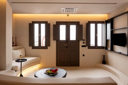 a living room with a door and a table at Caldera's Memories in Imerovigli