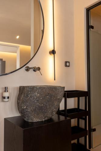 a bathroom with a large rock sink and a mirror at Caldera's Memories in Imerovigli