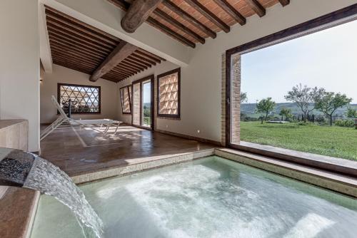een binnenzwembad in een huis met een groot raam bij Villanovia Country House in Volterra
