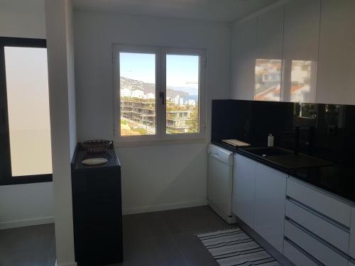 a kitchen with a counter and a sink and a window at The Sunrise of your Dreams with Total Ocean View in Funchal