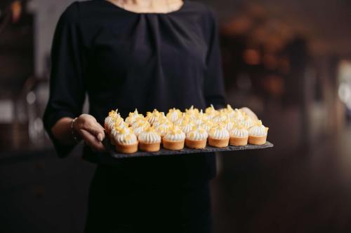 a woman is holding a tray of cupcakes at Best Western Malmo Arena Hotel in Malmö