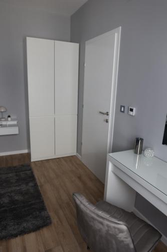 a white room with a desk and a chair at Apartmani Royal Osijek in Osijek