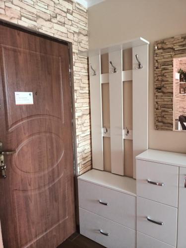 a closet with a wooden door and white dressers at Atrakcyjne Matejki in Świnoujście