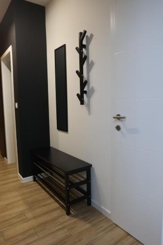 a room with a black bench on a white wall at Apartmani Royal Osijek in Osijek