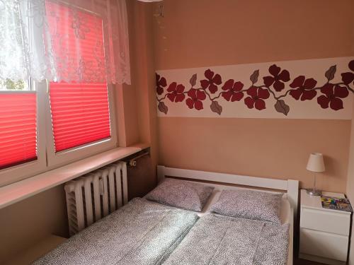 a small bedroom with a bed and two windows at Atrakcyjne Matejki in Świnoujście