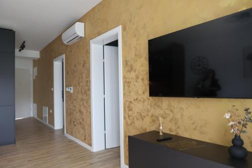 a living room with a television on a wall at Apartmani Royal Osijek in Osijek