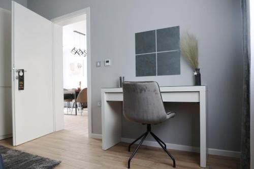 a desk with a chair in a room at Apartmani Royal Osijek in Osijek