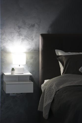 a bedroom with a bed and a nightstand with a lamp at Apartmani Royal Osijek in Osijek