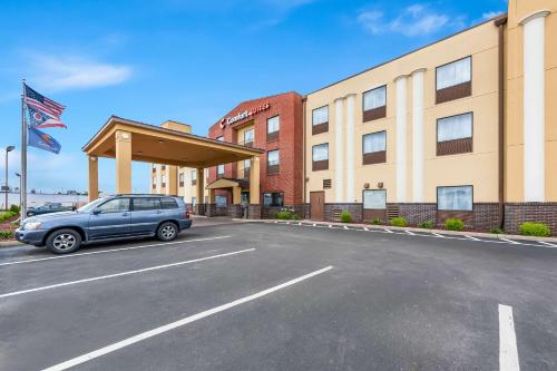 un'auto parcheggiata in un parcheggio di fronte a un hotel di Comfort Suites Columbus a Columbus