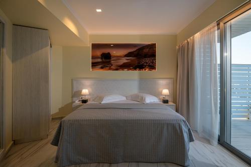 a bedroom with a bed and a painting on the wall at Alexandra Hotel&Apartments in Kos Town