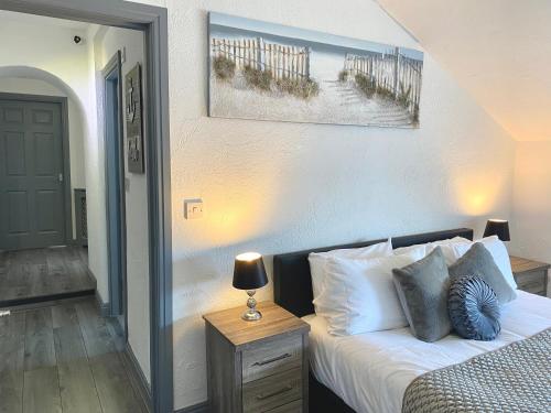 a bedroom with a bed and a table with a lamp at Simpson Beach View Apartments by Blackpool Service Apartments in Blackpool