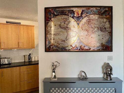 a large world map hanging on a wall in a kitchen at Simpson Beach View Apartments by Blackpool Service Apartments in Blackpool