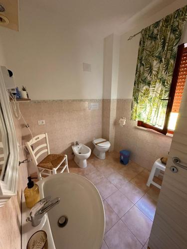 a bathroom with a sink and a toilet and a window at A Due Passi dal Centro in Favignana