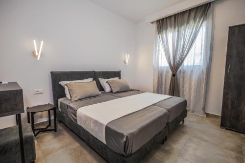 a bedroom with a large bed and a window at Stegna Sea & Sun in Archangelos
