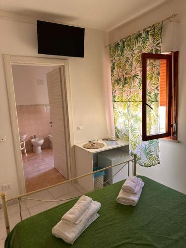 a bathroom with a bed and a sink and a mirror at A Due Passi dal Centro in Favignana