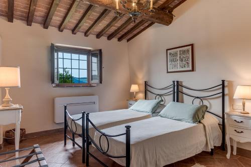 a bedroom with two beds and a chandelier at Villanovia Country House in Volterra