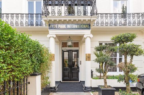 a white building with a black door and a balcony at Hyde Park International in London