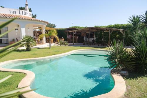 a swimming pool in a yard next to a house at The Lighthouse Hostel in Sagres