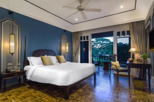 una camera con un grande letto bianco e un balcone di The Grand Luang Prabang, Affiliated by Meliá a Luang Prabang