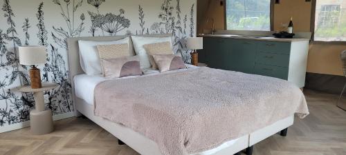 a bedroom with a bed and a kitchen with a sink at Glampinglodge 2 pers met hottub in Meerssen