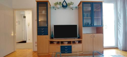 a living room with a tv in a cabinet at 3 min. away in Koprivnica