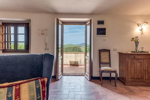 a living room with a couch and a sliding glass door at Villanovia Country House in Volterra