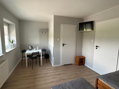 a room with a table and a door and a table and chairs at Milten Domaszewnica in Kolonia Domaszewnica