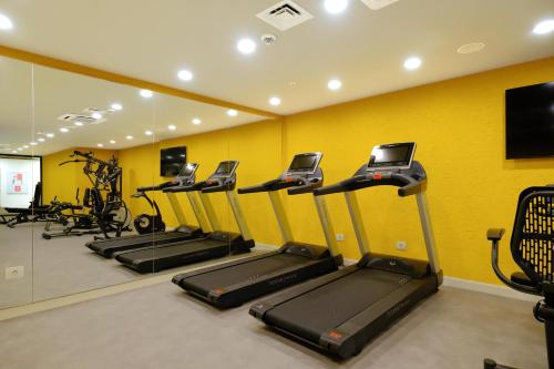 a row of treadmills in a gym with yellow walls at New Inn Hotel Old Town in Istanbul