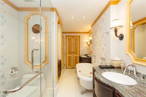 a bathroom with a sink and a shower and a toilet at The Grand Luang Prabang, Affiliated by Meliá in Luang Prabang
