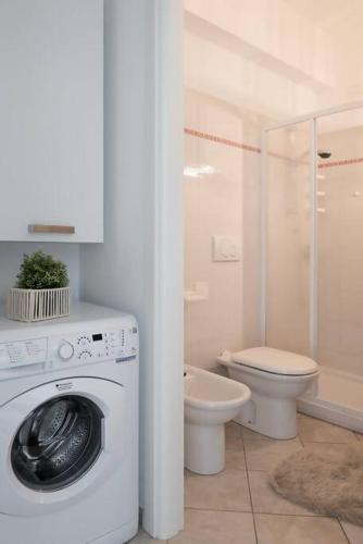 a bathroom with a washing machine and a toilet at fronte mare spiaggia - marine 59 in Diano Marina