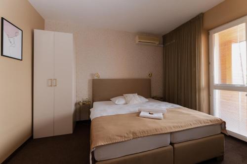 a bedroom with a bed with a towel on it at Penzion Tofi in Nitra